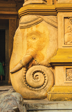 The elephant image at the temple entrance, whose trunk has been worn out by the topping of coins for good luck