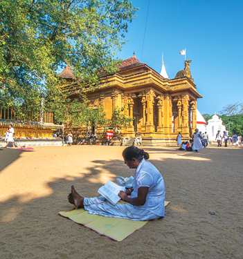 Devotees sit on the temple ground for veneration