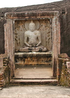 The cross-legged Buddha statue flankedby unfinished rock carvings