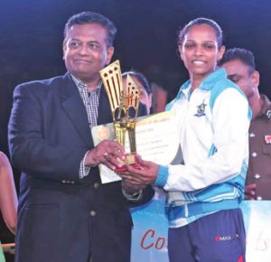 Ishara receives her trophy from retired Rear Admiral Prof Shemal Fernando