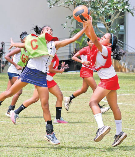 Nashaya Silva representing Ladies College (right) and Amavi Amaranayake from Girls' Hgh School in Kandy tussle for the ball in their 100th netball encounter yesterday in Colombo (Pix: Chintaka Kumarasinghe)