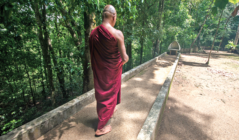 One posture of meditation is walking with a slow measured tread and chanting. Every forest hermitage has platforms for walking meditation. This bhikkhu is engaged in meditation on a paved walkway which winds through the trees at the Bodhinagala forest hermitage