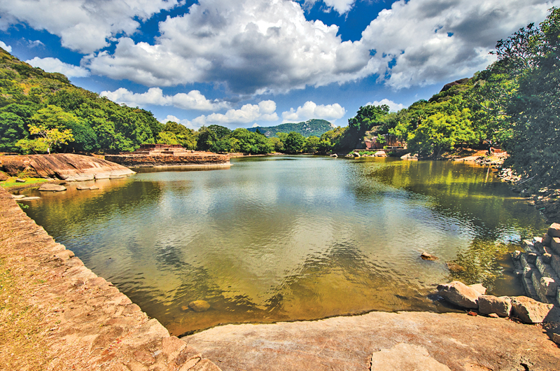 The Kaludiya Pokuna with reflections of trees and boulders of the neighbouring forests and mountains 
