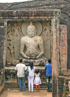 The seated Buddha statue hewn into the rock boulder