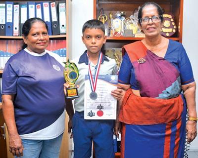 Chanuga with his school Principal, R.D. Balasooriya and Spots Teacher, Amara Paranavithana